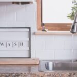 faucet with water and soap in bathroom with wash inscription