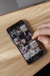 crop person browsing smartphone on wooden table
