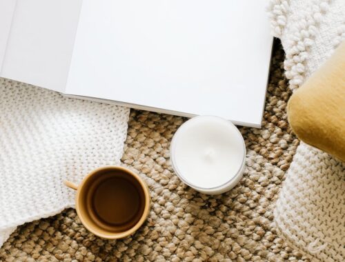 opened diary placed on table near mug and candle