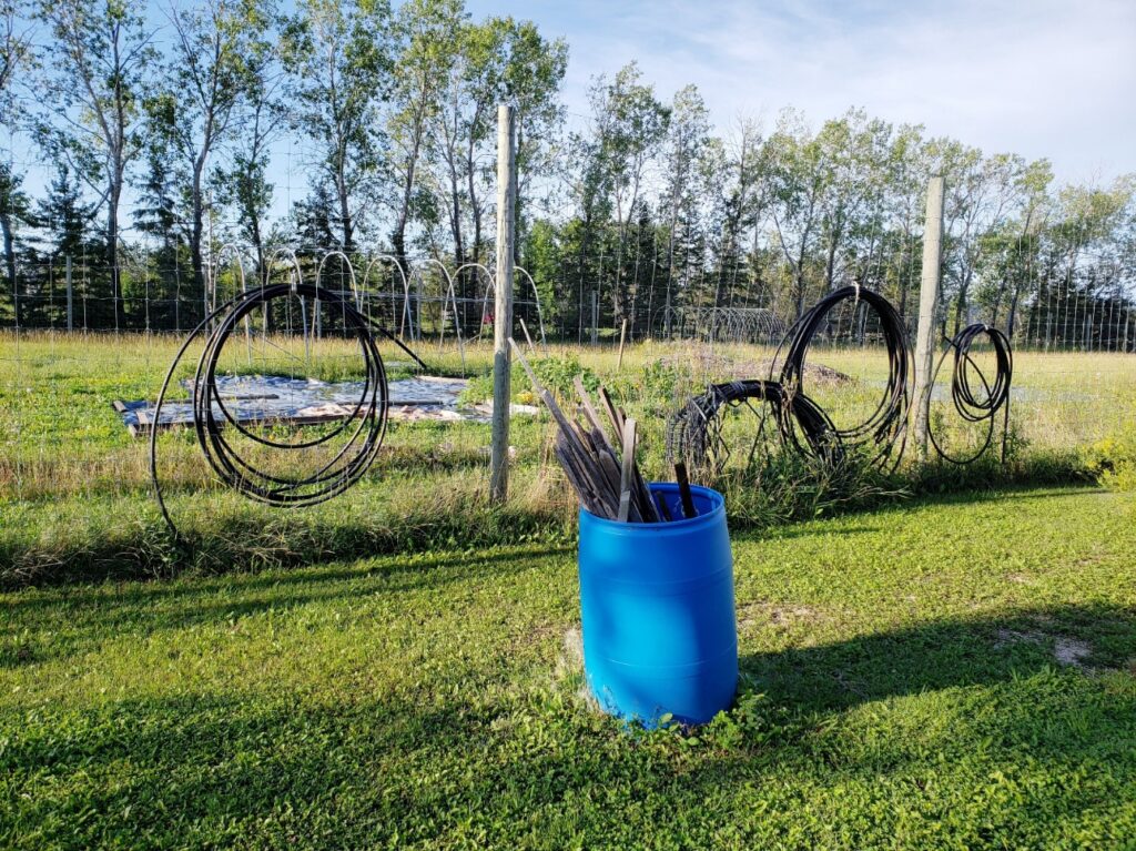 Empty garden PVC water lines hung on fence